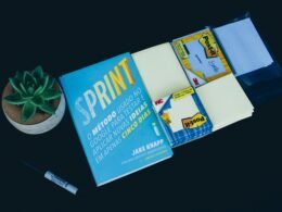 Ein Sprint Buch liegt auf einem Tisch neben einem schwarzen Marker – beide als Tools für agiles Vorgehen im Arbeitsalltag.