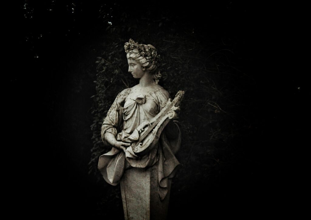 Statue einer Frau hält eine Laute und steht umgeben von Gartenpflanzen im Freien