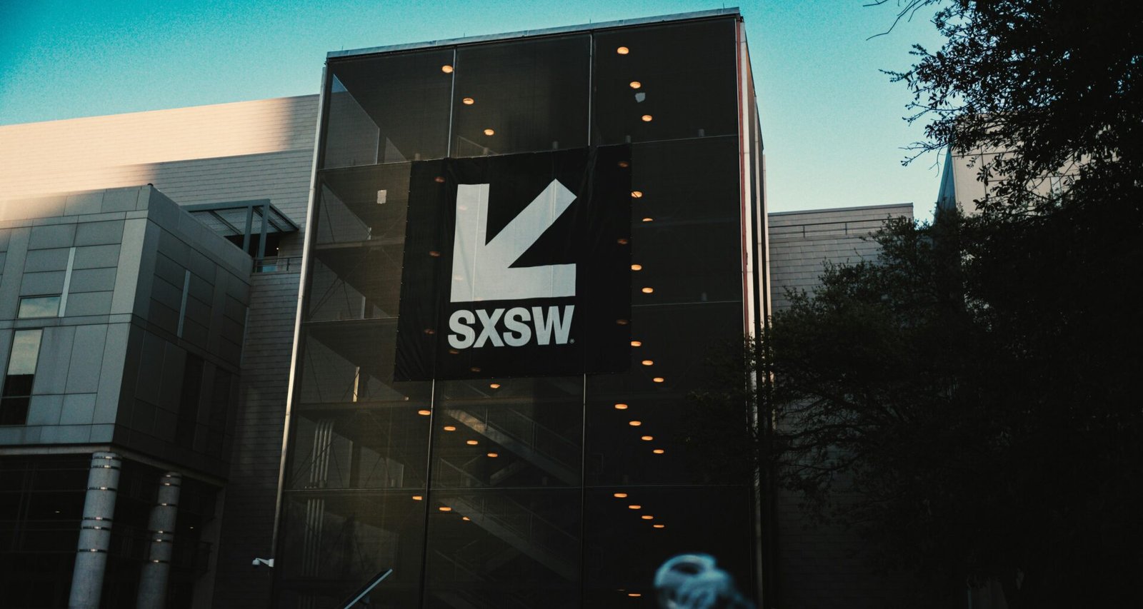 Das SXSW-Gebäude mit großem Logo vor strahlend blauem Himmel, modernes Design und klare Linien in Austin