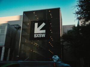 Das SXSW-Gebäude mit großem Logo vor strahlend blauem Himmel, modernes Design und klare Linien in Austin