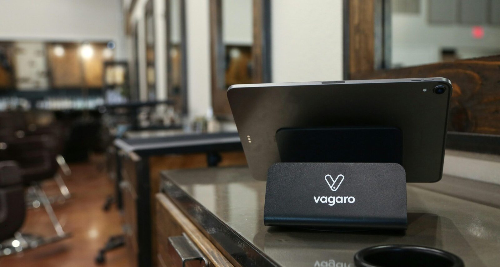 Tablet auf Standfuß mit Vagaro-Logo in einem Salon, dargestellt als Beispiel für digitale Salonlösungen
