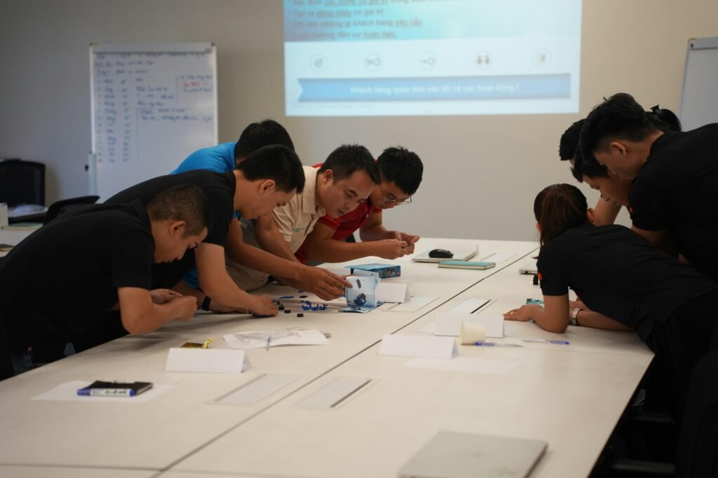 Mehrere Personen sitzen zusammen an einem Tisch und arbeiten als Team an gemeinsamen Projekten in einem modernen Büro.