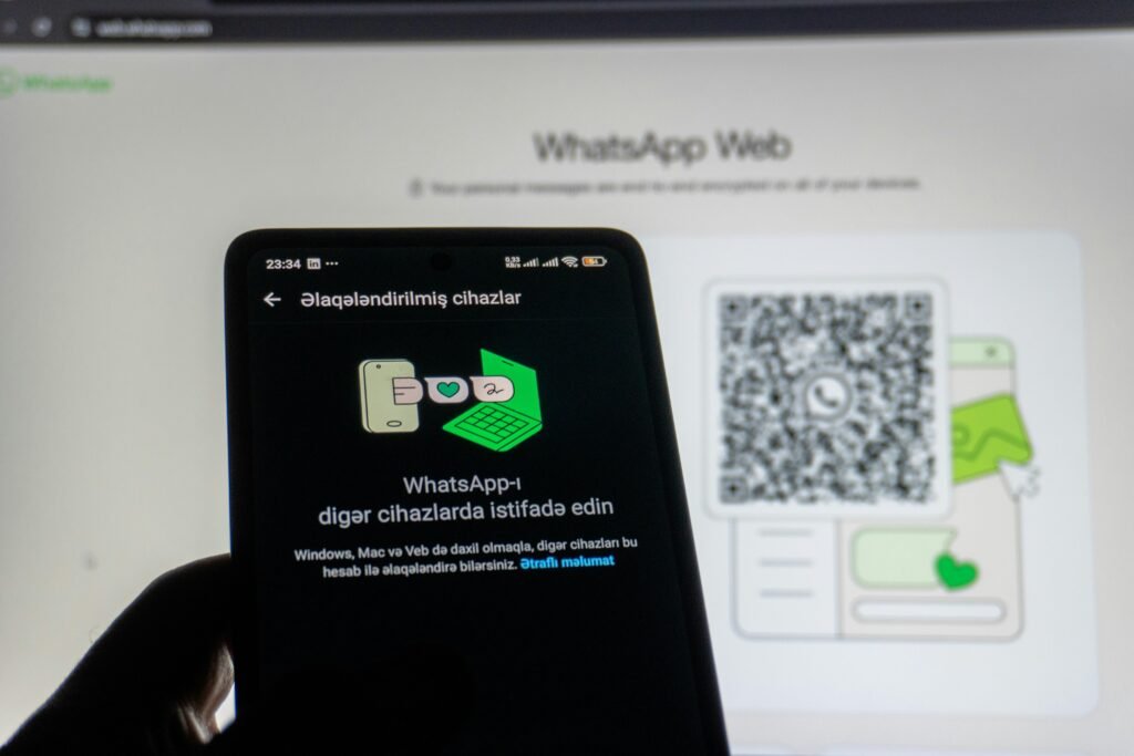 Ein Smartphone wird genutzt, um einen WhatsApp Web QR-Code direkt vom Computerbildschirm zu scannen.