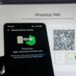 Ein Smartphone wird verwendet, um einen WhatsApp Web QR-Code auf einem Computerbildschirm zu scannen