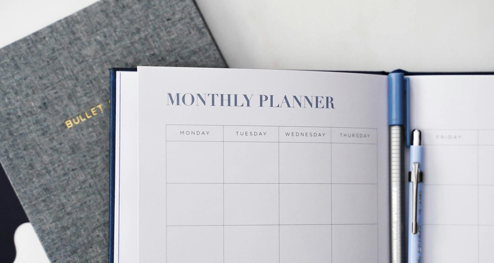 Moderner Arbeitsplatz mit Laptop, Tablet und Kaffeetasse auf einem Schreibtisch, fotografiert von 2H Media