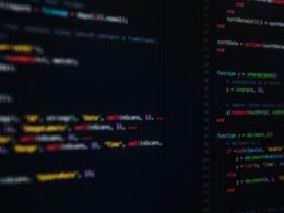 Ein aufgeräumter moderner Schreibtisch mit Laptop, Smartphone und Notizbuch als Sinnbild für zeitgemäßes Arbeiten