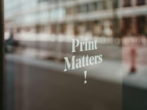 Heller Arbeitsplatz mit Laptop, Smartphone und Notizbuch auf einem modernen Schreibtisch