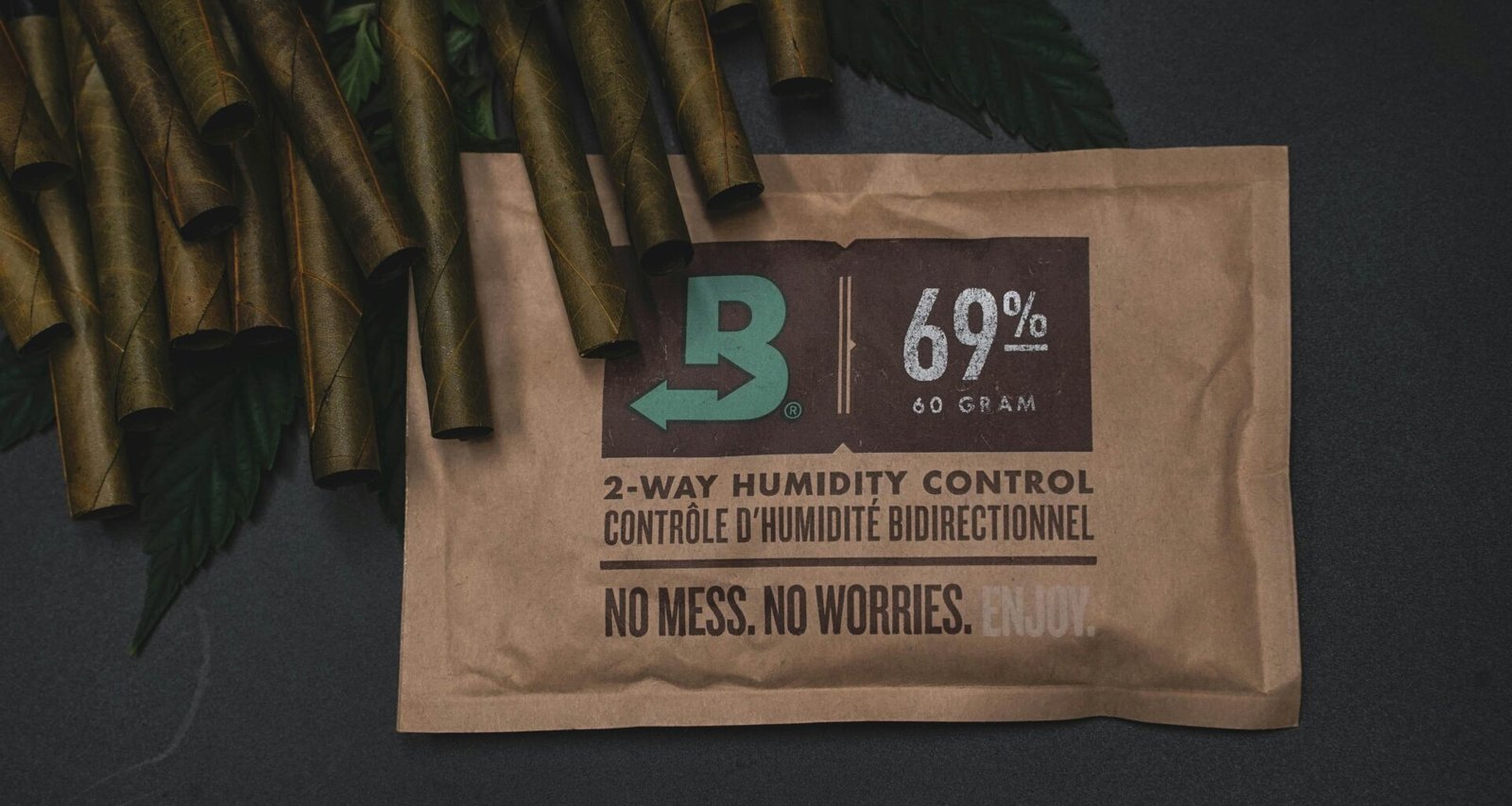 Ein Laptop und ein Notizbuch liegen auf einem Holztisch, begleitet von einem Kaffeebecher in hellem Tageslicht.