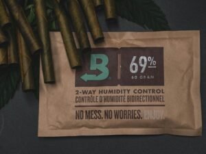 Ein Laptop und ein Notizbuch liegen auf einem Holztisch, begleitet von einem Kaffeebecher in hellem Tageslicht.