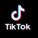 Das TikTok Logo ist mittig auf einem schwarzen Hintergrund platziert und steht klar im Fokus der Bildkomposition.