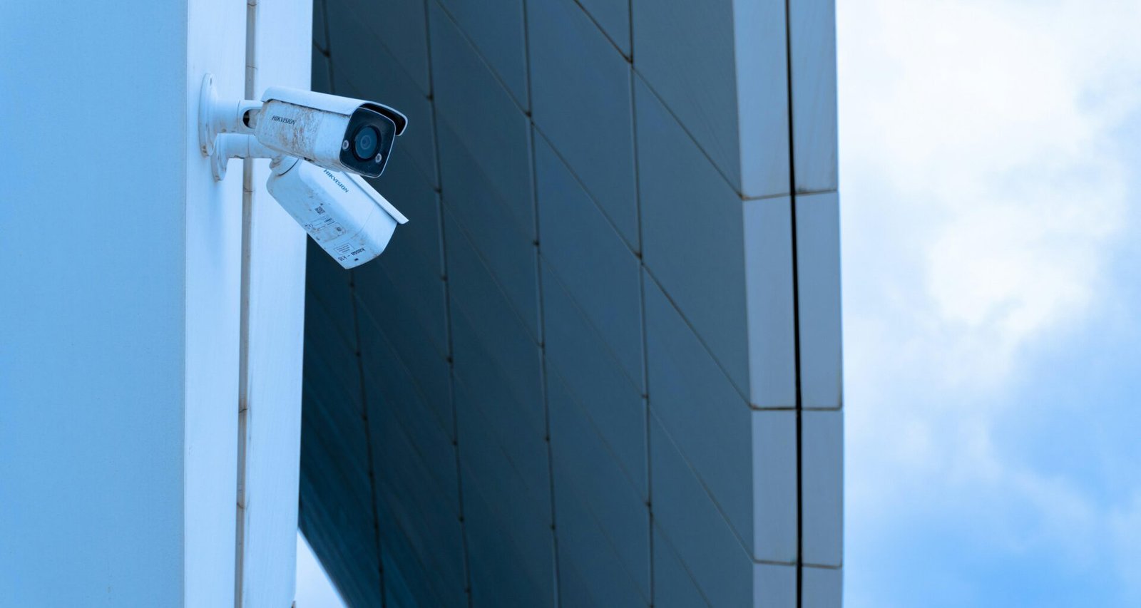 Mehrere Sicherheitskameras sind nebeneinander an der Wand eines Gebäudes zur Überwachung montiert