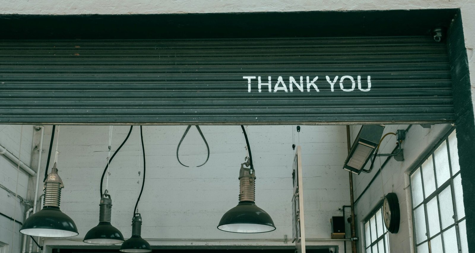 Mehrere assortierte Pendelleuchten hängen von der Decke eines modernen Innenraums und beleuchten den Raum gleichmäßig.