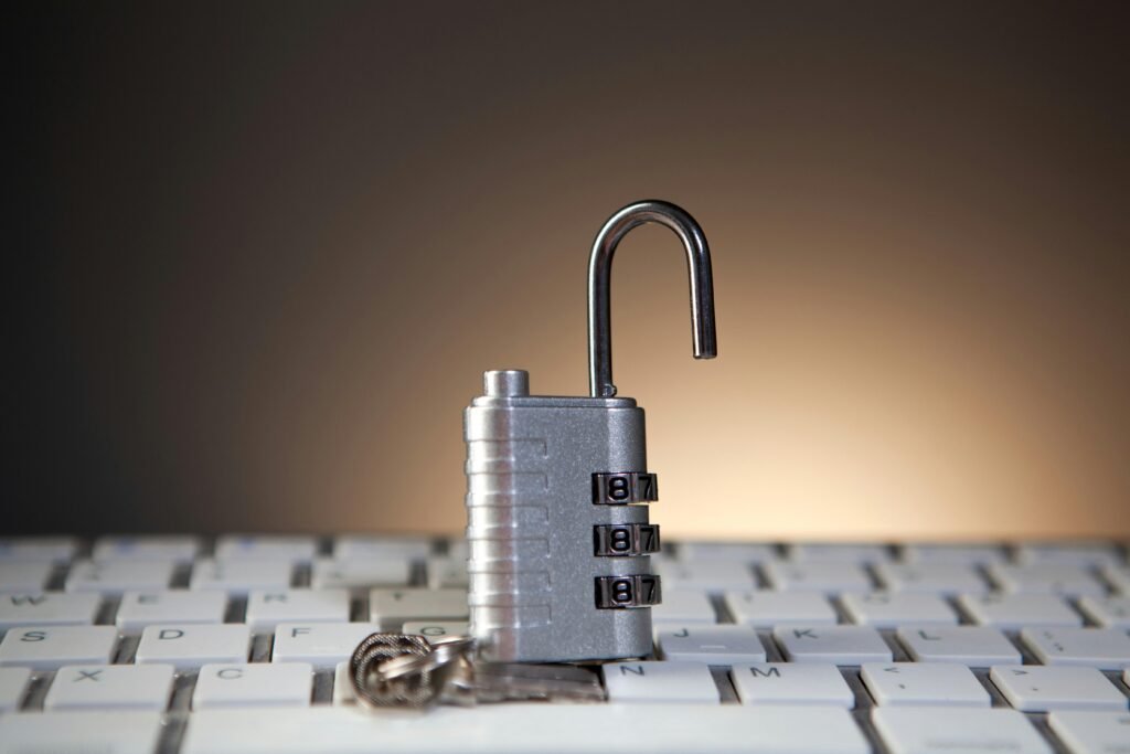 Ein geöffnetes Zahlenschloss liegt auf einer Computer-Tastatur und symbolisiert IT-Sicherheit und Datenschutz.