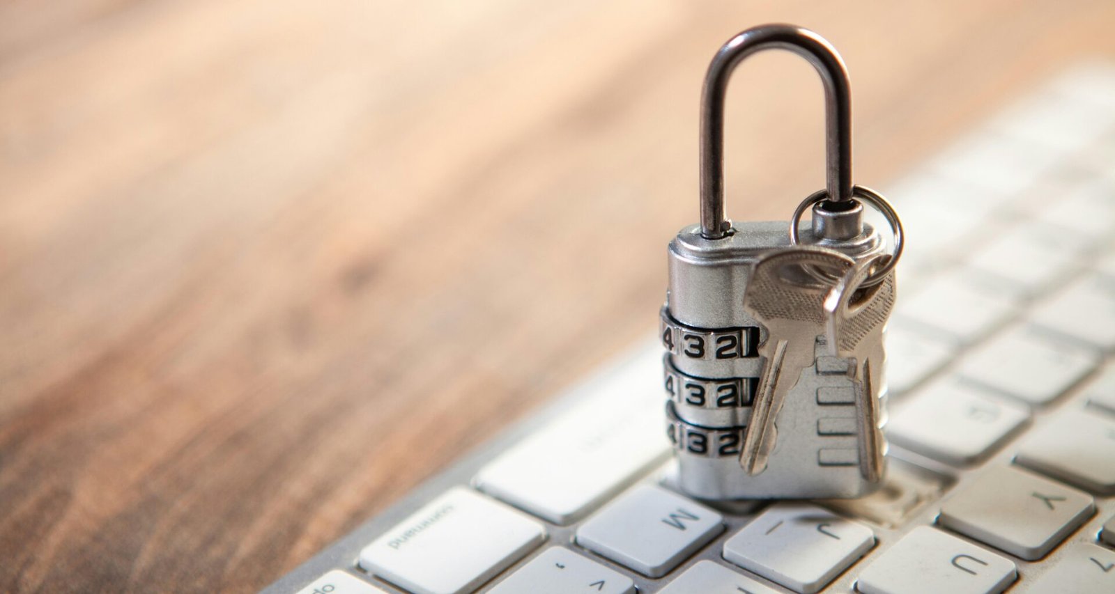 Ein Vorhängeschloss und Schlüssel liegen auf einer Computertastatur und symbolisieren IT-Sicherheit und Datenschutz