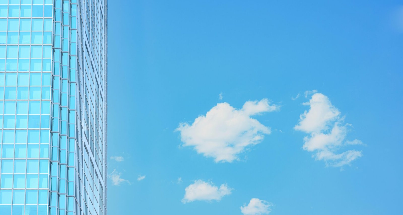 Vorhangfassade aus Glas an einem modernen Gebäude mit geometrischer Struktur, aufgenommen bei Tageslicht