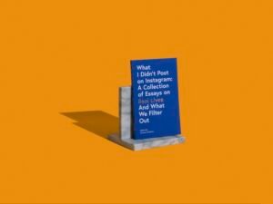 Das Buch „What I didn't post on Instagram“ steht auf grauen Marmorbuchstützen, fotografiert aus der Nähe auf glatter Oberfläche.