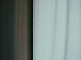 Weiße, halbtransparente Vorhänge lassen natürliches Licht in einen ruhigen, hellen Raum strömen