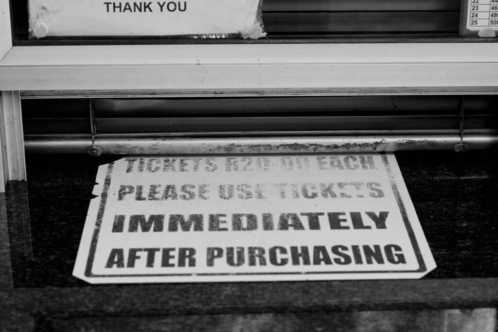 Ein weiß-schwarzes Straßenschild zeigt klare Richtungshinweise im urbanen Straßenverkehr.