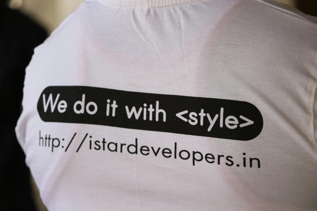Weißes und schwarzes T-Shirt mit dem Print 'we do it with ', fotografiert auf weißem Hintergrund