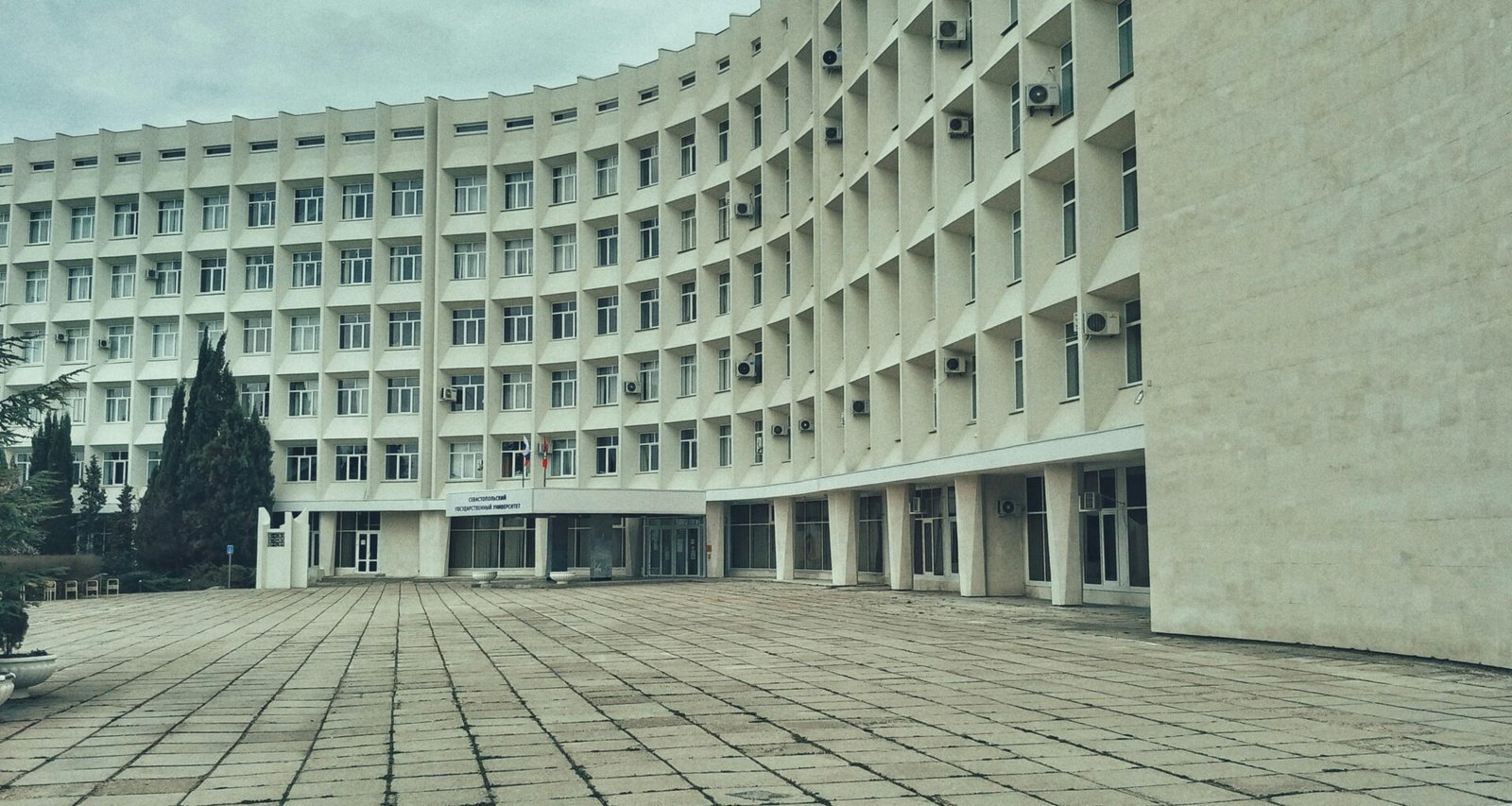 Weißes Betongebäude mit klaren Linien und moderner Fassade, aufgenommen tagsüber bei natürlichem Licht