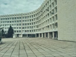 Weißes Betongebäude mit klaren Linien und moderner Fassade, aufgenommen tagsüber bei natürlichem Licht