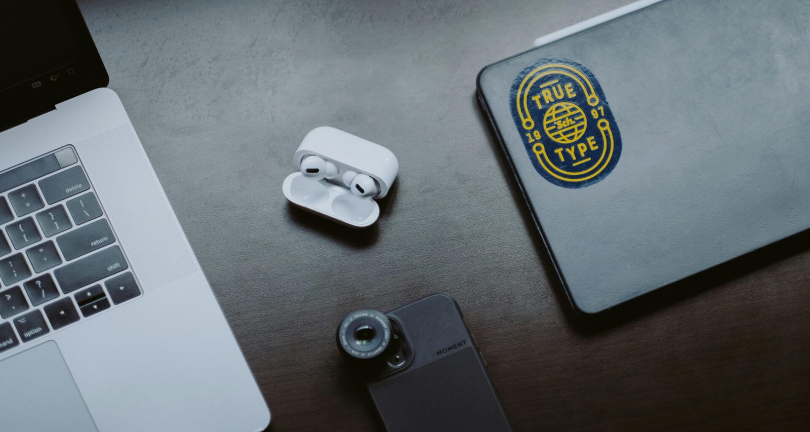 Weiße Apple EarPods liegen auf einer grauen iPhone-Hülle und zeigen modernes Smartphone-Zubehör in minimalistischem Stil.