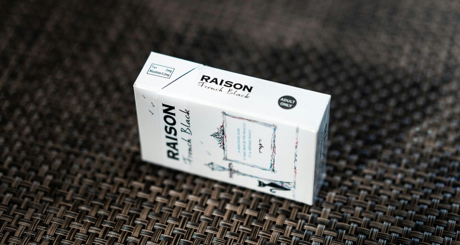 Weiße rechteckige Box platziert auf strukturiertem, braunen Textilstoff in neutralem Licht