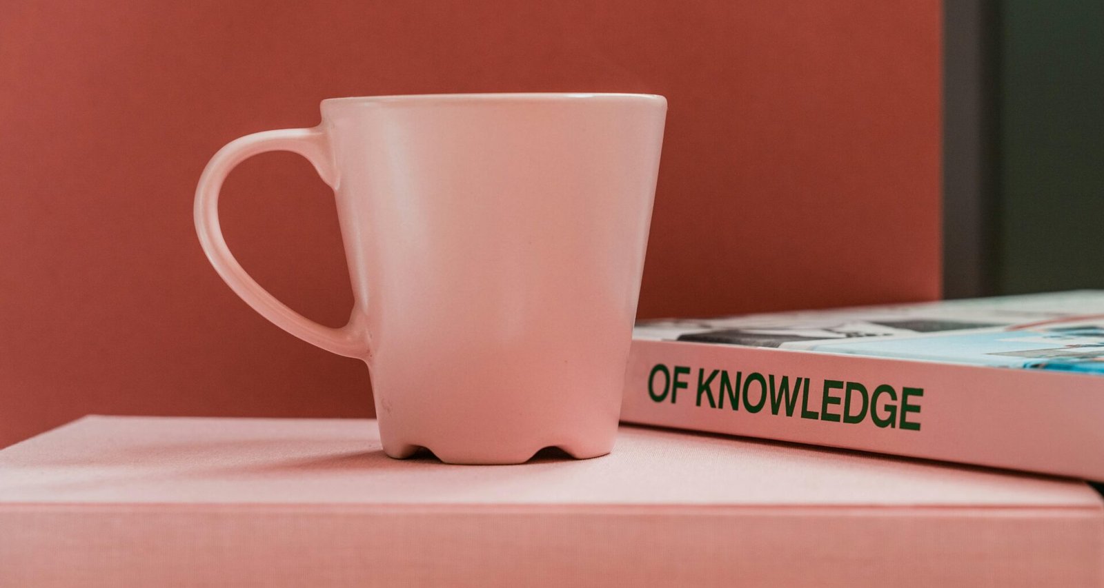 Weiße Keramiktasse auf weißem Tisch, neutral fotografiert aus der Vogelperspektive als Symbol für Minimalismus