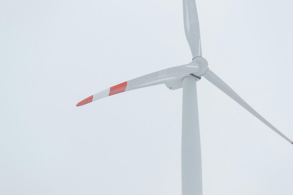 Weiße Windkraftanlage mit roten Elementen zur Stromerzeugung bei Tag, Symbol für erneuerbare Energien und Technologie