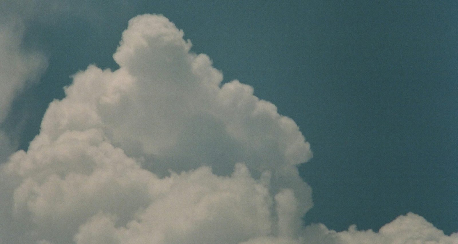 Mehrere weiße Wolken verteilen sich tagsüber am hellen Himmel und bieten eine klare, offene Ansicht der Atmosphäre.