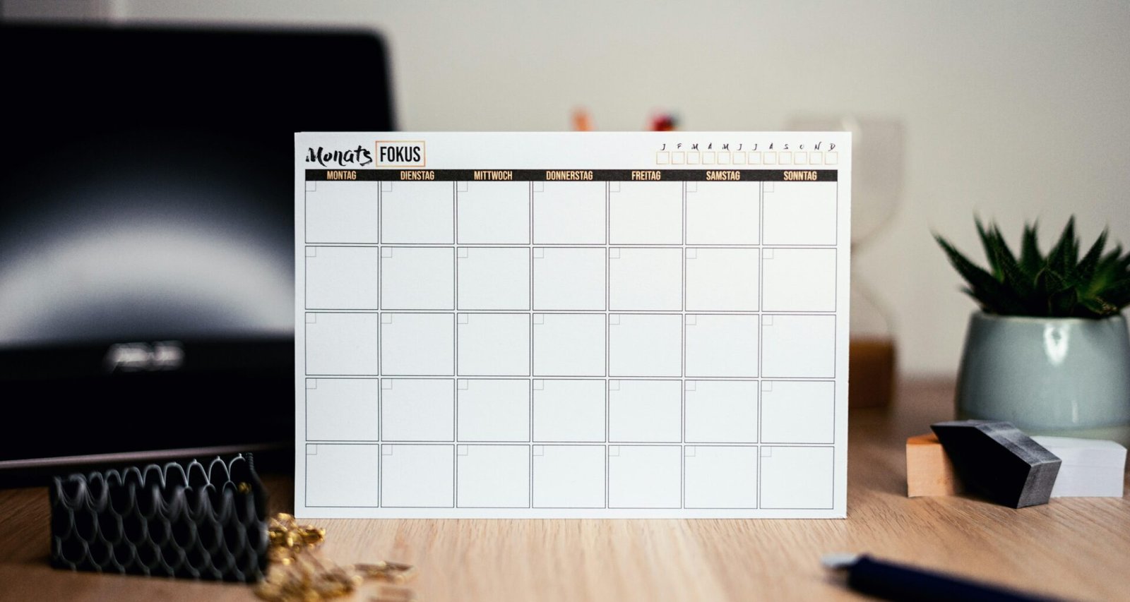 Weißer Kalender auf einer Oberfläche, zeigt übersichtliche Tages- und Monatsfelder zur Planung von Terminen und Aufgaben.