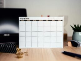 Weißer Kalender auf einer Oberfläche, zeigt übersichtliche Tages- und Monatsfelder zur Planung von Terminen und Aufgaben.