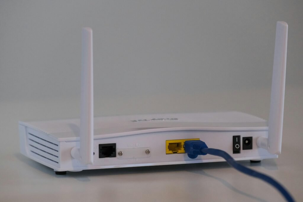 Weißer WLAN-Router auf einem weißen Tisch, minimalistisches Design, geeignet für moderne Heim- oder Büronetzwerke.