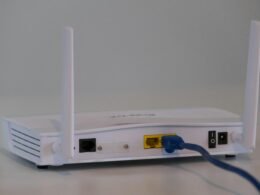 Weißer WLAN-Router auf einem weißen Tisch, minimalistisches Design, geeignet für moderne Heim- oder Büronetzwerke.