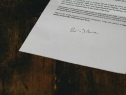 Weiße Druckerpapierblätter auf einem braunen Holztisch, arrangiert in einer typischen Büroumgebung, Aufnahme von Annie Spratt