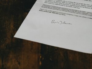 Weiße Druckerpapiere auf braunem Holztisch, bereit für den Einsatz bei Büroarbeiten oder kreativen Projekten.