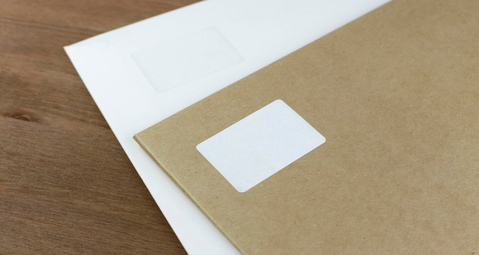Weiße Druckerpapierbögen liegen sauber auf einem braunen Holztisch. Geeignet für Artikel rund um Büro oder Organisation.