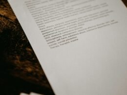 Ein Stapel weißes Druckerpapier liegt auf einem schwarzen und braunen Granittisch in moderner Büro-Umgebung.