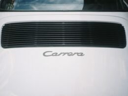 Heckansicht eines weißen Autos mit Carrera-Emblem, Fokus auf die Linienführung und das sportliche Design