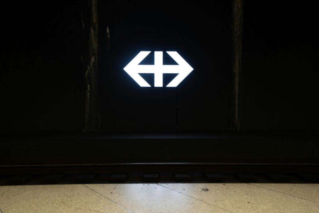 Weiße Pfeilmarkierung auf einer schwarz gestrichenen Holztür, aufgenommen als Symbol für klare Richtung und Orientierung.