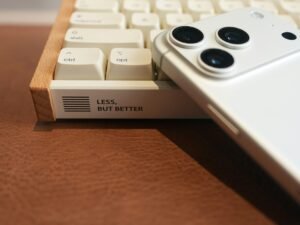 Weiße Smartphone liegt auf einer Retro-Tastatur und verbindet modernes Design mit klassischer Technik.