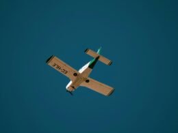 Weißes und braunes Flugzeug fliegt tagsüber unter blauem Himmel, aufgenommen von Grianghraf.