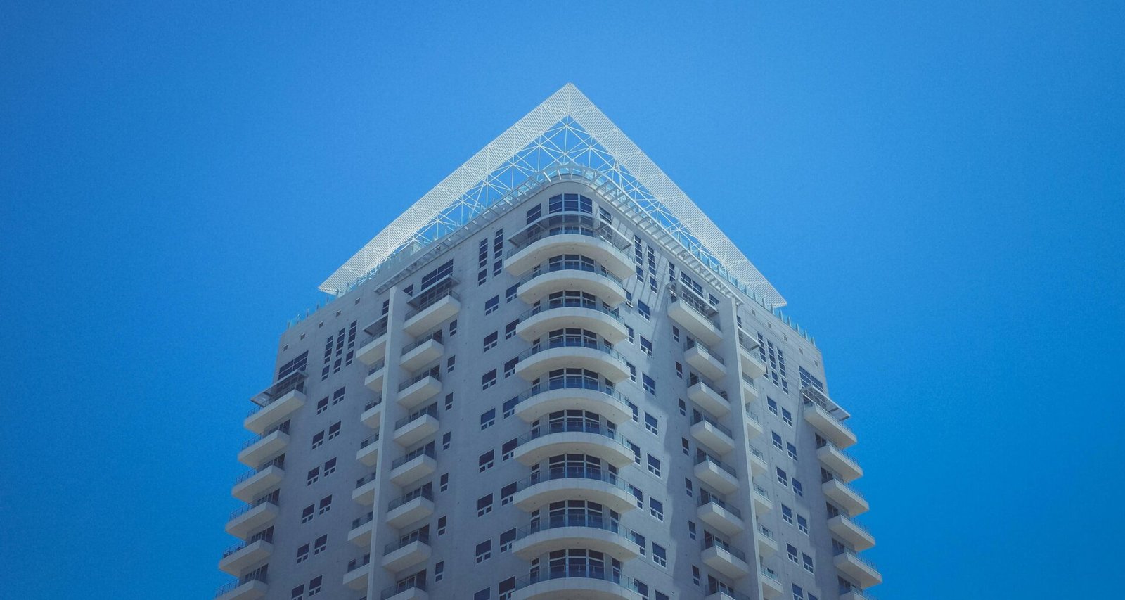 Weiß-graues Betongebäude mit klaren Linien bei Tageslicht, Fokus auf moderne Architektur und urbanes Ambiente