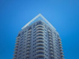 Weiß-graues Betongebäude mit klaren Linien bei Tageslicht, Fokus auf moderne Architektur und urbanes Ambiente