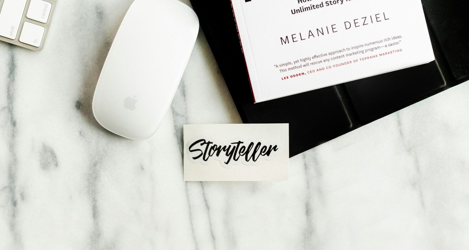 Weiße Apple Magic Mouse liegt auf einem weißen Papier, fotografiert aus der Vogelperspektive.