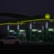 Moderne WOG Tankstelle mit überdachten Zapfsäulen und beleuchtetem WOG-Logo in städtischem Umfeld am Abend