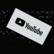 YouTube Logo auf dunkler Computertastatur, symbolisiert digitale Medien und Technologie im Online-Marketing-Umfeld.
