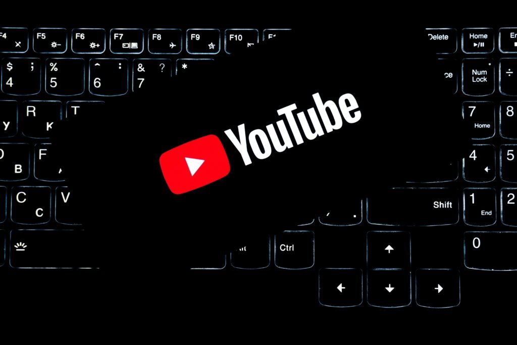 Youtube Logo ist auf einer leuchtenden Computertastatur zu sehen, Symbol für digitale Medien und Online-Kommunikation.