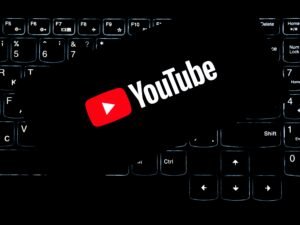 Youtube Logo ist auf einer leuchtenden Computertastatur zu sehen, Symbol für digitale Medien und Online-Kommunikation.