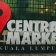 Haupteingang und Außenbereich des Zentralmarkts in Kuala Lumpur mit Menschen und Marktständen.